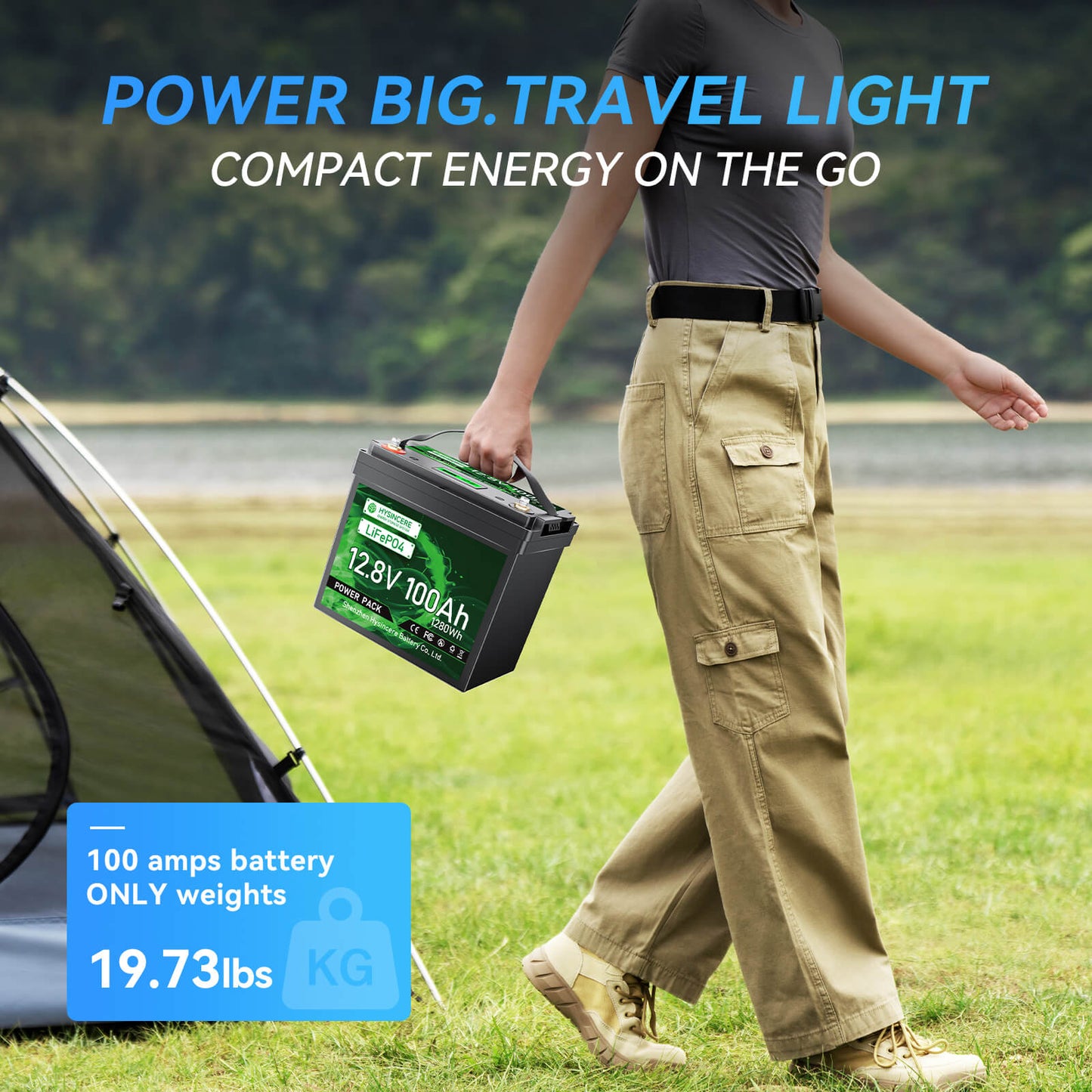 Person holding a battery pack with camping gear and scenic background
