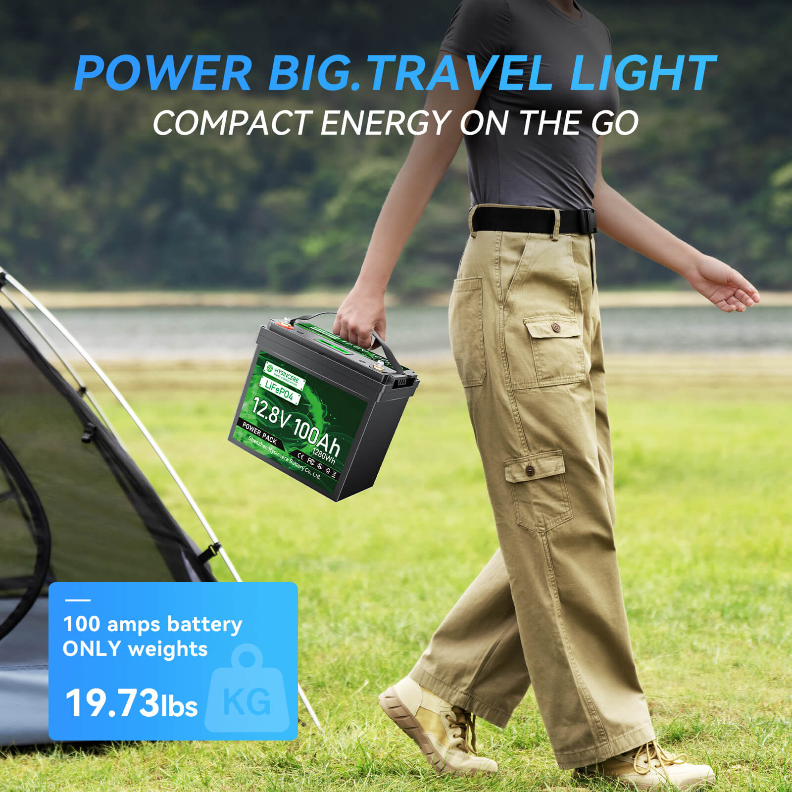 Person holding a battery pack with camping gear and scenic background