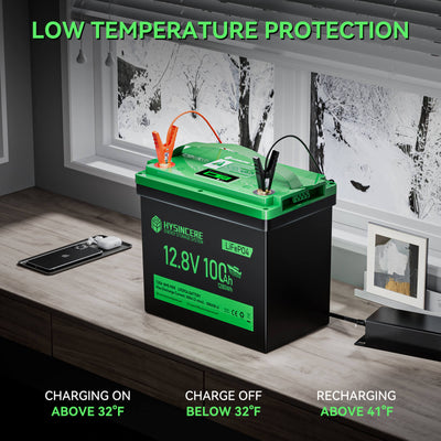 Green and black battery on a wooden surface with text about low temperature protection.